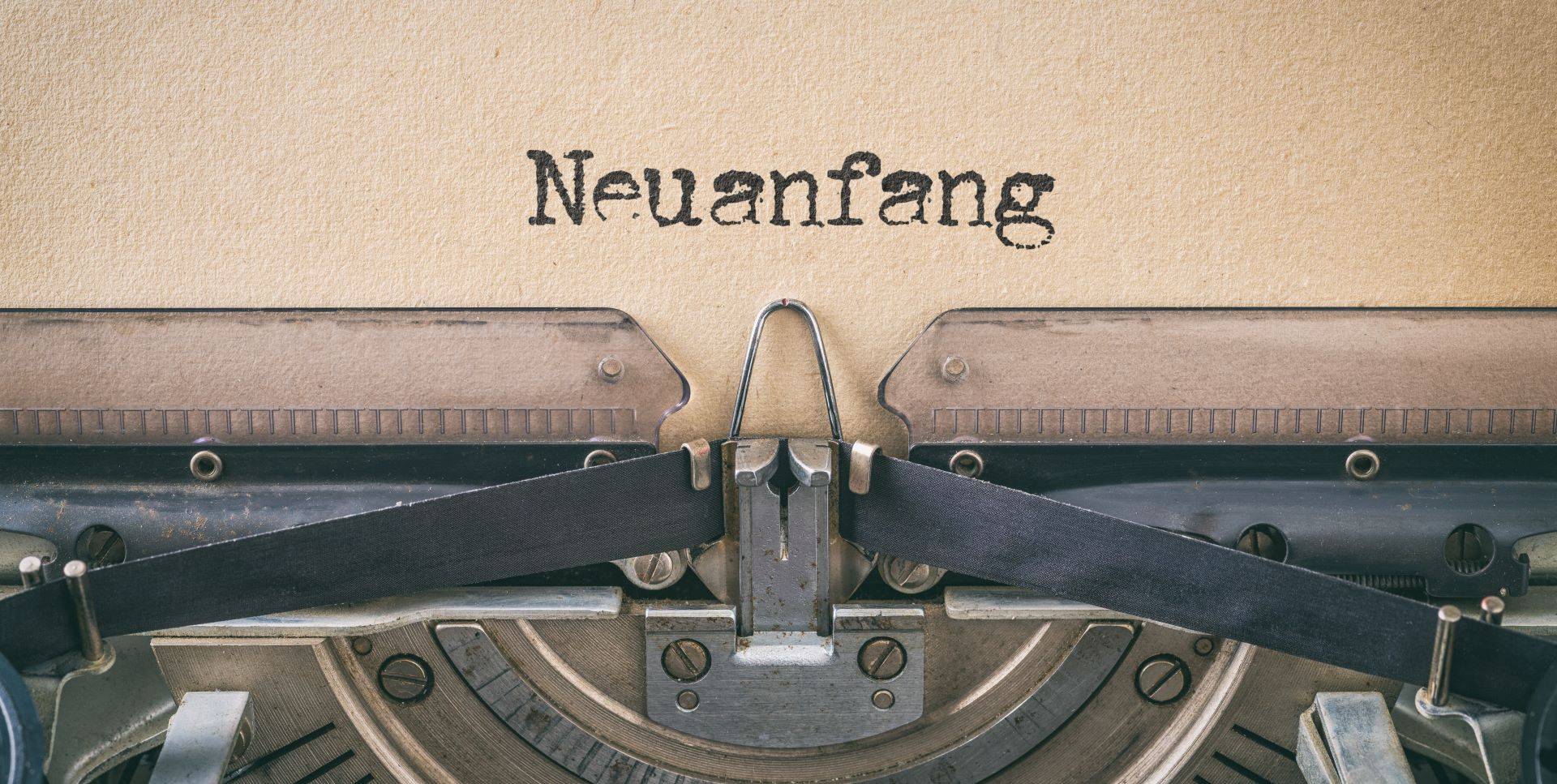 Alte Schreibmaschine schreibt "Neuanfang"