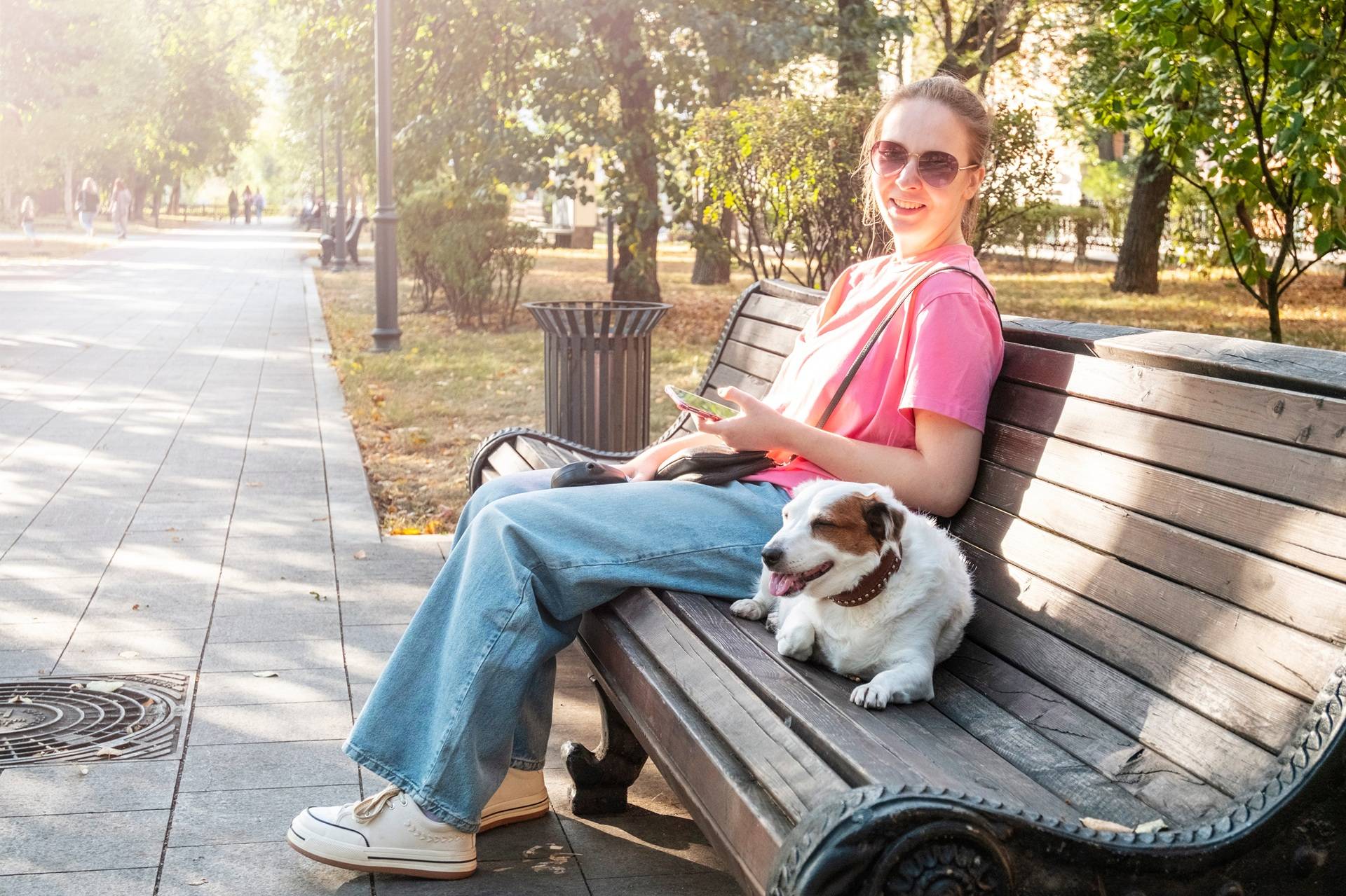 Frau sitzt mit Hund auf Bank im Park | Hundefutter für Allergiker